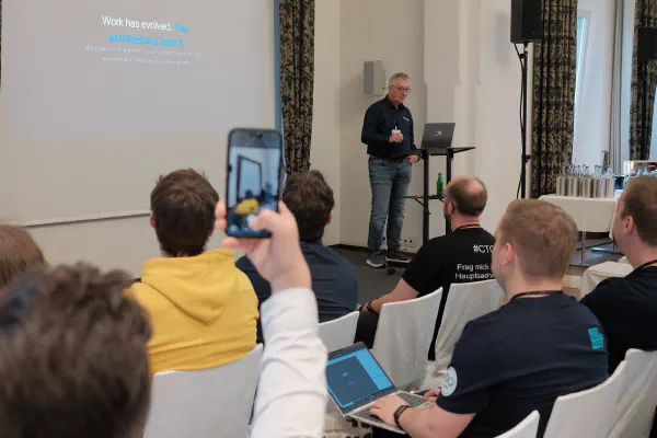 An attendee filming a talk with a phone